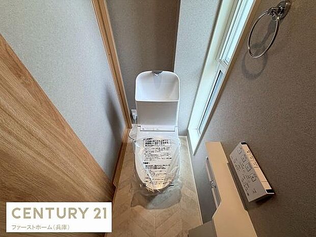 トイレには手洗い一体型の設備が備わっております。窓から自然光が差し込む明るい空間です。すっきりとした内装で清潔感があります。ペーパーホルダーやタオルリングも設置されています。