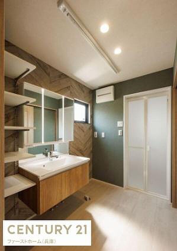 広々とした洗面スペースが魅力です。収納棚が充実しているので整理整頓も快適に行えます。窓付きで自然光が差し込み明るい空間です。木目調のデザインが温かみを感じさせます。清潔感のある内装もポイントです。