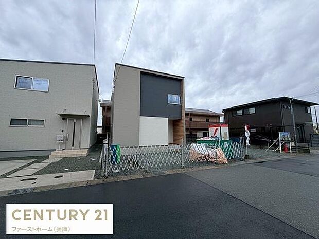 シンプルでスタイリッシュな外観が印象的です。周囲には同様の新しい住宅が並び統一感があります。前面道路が広くアクセスしやすい立地です。建物は直線的なデザインが特徴となっています。