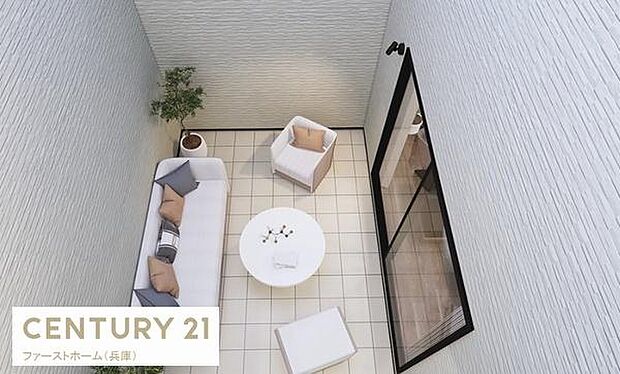 清潔感のあるタイル張りの空間です。屋外の自然光が差し込む設計になっています。シンプルな家具配置で使いやすさが際立ちます。壁が高くプライベートな雰囲気です。観葉植物がアクセントとなっています。