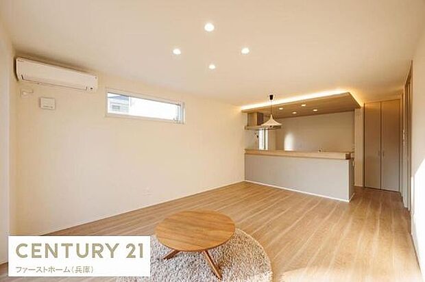 明るさが広がるリビング空間です。シンプルな内装でコーディネートしやすいデザインです。窓から自然光が入り日中も快適に過ごせます。対面式キッチンが隣接しています。床の色味が温かみを感じさせます。