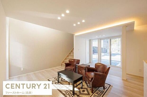 リビングは大きな窓から明るい光が差し込み開放感があります。落ち着いた色合いの床材と天井照明が上質な印象を与えます。シンプルながらも洗練された空間が魅力的です。ゆとりを感じられる広さを確保しています。