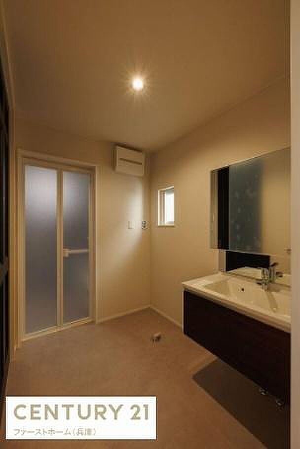 落ち着いた色合いの洗面台で清潔感のある空間です。大きな鏡が設置されており毎日の身支度も快適に行えます。窓付きで適度な採光があり明るい雰囲気です。収納スペースもあり使い勝手に配慮されています。