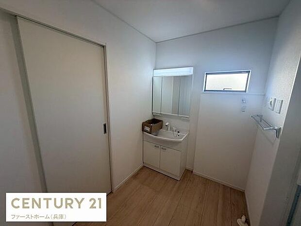 洗面台と収納スペースが一体となった使い勝手の良い洗面所です。シンプルな内装で清潔感があります。小窓があるため自然光が差し込み明るい空間です。床にはナチュラルな色味のフローリングを使用しています。