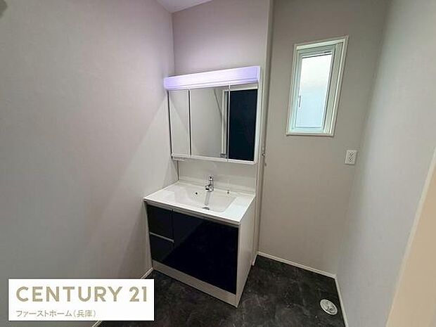 すっきりとしたデザインの洗面台が設置されています。ミラー収納付きで使いやすさが特徴です。小窓からの採光もあり明るい雰囲気です。床はダークトーンで落ち着いた印象です。