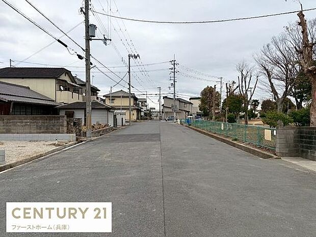前面道路はゆったりとした幅員があり車の出し入れがスムーズです。周辺には整った街並みが広がっています。現地は落ち着いた環境が魅力です。道路沿いの緑も印象的なロケーションです。