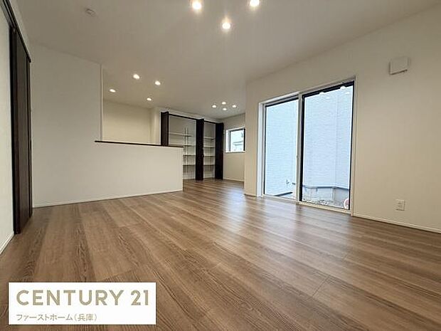 開放感のあるリビングが広がり落ち着いたフローリングが印象的です。大きな窓から自然光がしっかり入ります。天井のダウンライトが空間をすっきりと照らしています。