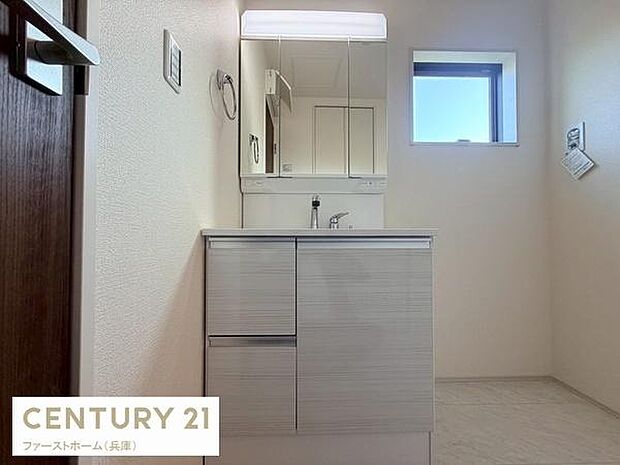 洗面台には収納スペースが備わっており整理整頓がしやすい仕様です。明るい照明が設置されていて手元が見やすくなっています。窓があるため換気もしやすい設計です。清潔感のある内装が印象的です。