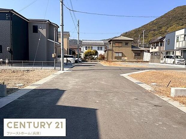 前面道路は舗装されており周辺は落ち着いた住宅街となっています。両側には住居が並び視界も開けています。電柱や電線の配置も整っていて日当たりも確保しやすい印象です。