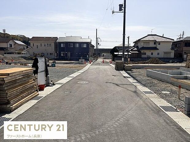現地から前面道路を望む写真です。周囲には住宅が整然と並び道路も見通しの良い造りとなっています。静かで落ち着いた雰囲気が伝わります。