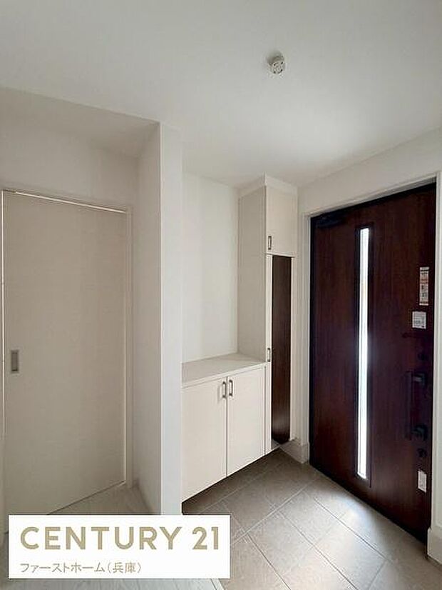 明るさを感じる玄関スペースです。すっきりとしたデザインの収納が備わっています。ドアにはスリット窓があり採光にも配慮されています。シンプルな配色で清潔感があります。