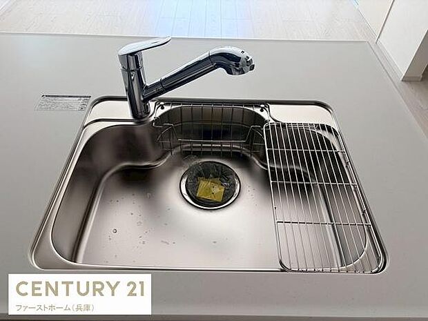 シンプルなデザインのシンクが特徴的です。水栓は取り回しのしやすい形状となっています。シンク横に水切りスペースも設けられています。ステンレス仕上げで清潔感があります。使いやすさが考慮されたキッチンです。