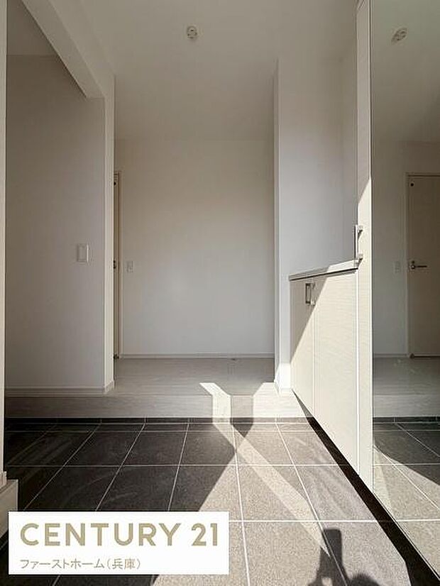 玄関にはシンプルなデザインが施されすっきりとした第一印象を与えます。自然光がしっかりと差し込み明るい空間となっています。収納スペースも備わっているため使い勝手も意識されています。