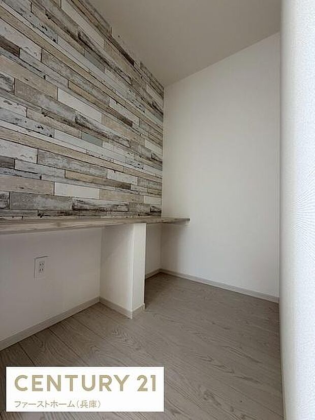 壁面の木目調デザインが空間にアクセントを加えています。シンプルな内装は幅広い用途に対応しやすいです。床や壁の色合いが落ち着いた雰囲気を演出しています。