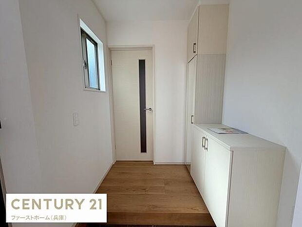 白を基調とした玄関は明るく清潔感のある空間です。窓から自然光が入り玄関全体をやさしく照らします。収納スペースも備わっており玄関まわりをすっきり保てます。シンプルなデザインが特徴です。