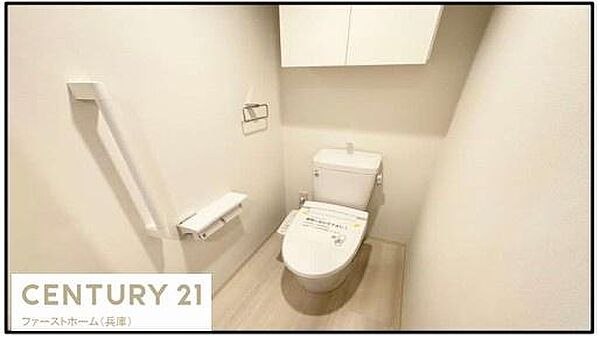 白を基調とした内装で明るく清潔感のあるトイレです。手すりが設置されており使いやすさに配慮されています。収納スペースも確保されておりすっきりとした印象です。スペースがゆったりしています。