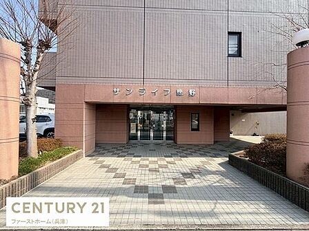 広々としたロビーがエントランスを印象的に演出しています。タイル張りの床が美しく整然とした空間が迎えてくれます。大きなガラス扉が開放感を与えています。周囲の植栽も丁寧に整えられています。