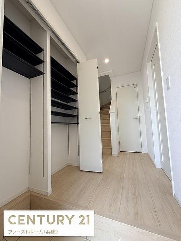 玄関には収納スペースが充実しており整理しやすくなっています。明るい色合いの床材が印象的です。玄関から階段までの動線もスムーズで廊下もすっきりとした見た目です。