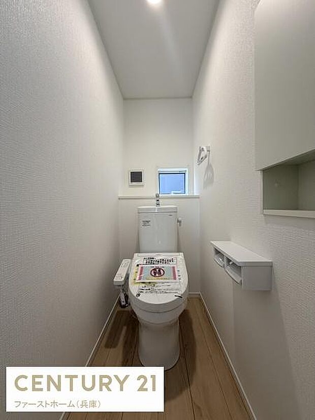 シンプルで落ち着いた印象のトイレ空間です。小窓が設けられており自然光が入る設計となっています。壁や床の色合いが調和しており清潔感があります。