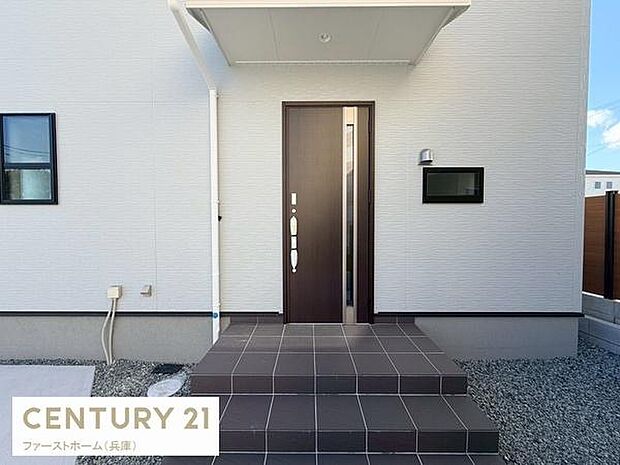 シンプルで落ち着いた印象の玄関です。飽きのこないデザインの玄関扉がポイントです。ゆとりのあるアプローチが空間を広く感じさせます。屋根付きで雨の日の出入りも安心です。