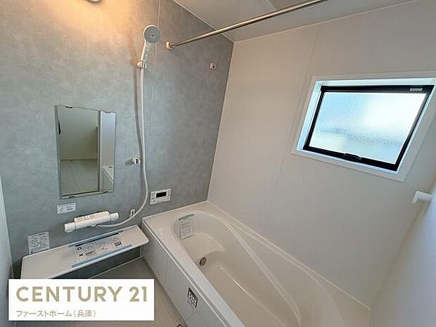 清潔感のある壁面が特徴的なバスルームです。窓があり明るさと換気を確保できます。浴槽はゆったりとした設計で毎日のリフレッシュに役立ちます。使いやすいシャワーもポイントです。