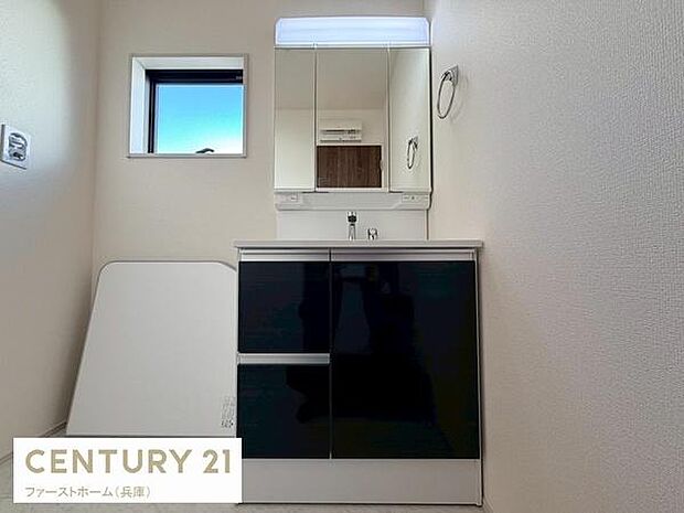 シンプルで清潔感のある洗面台が設置されています。窓からの自然光が明るさを確保し使いやすい空間です。収納スペースもしっかり確保され日常の使い勝手に配慮されています。鏡も大きく身支度に便利です。