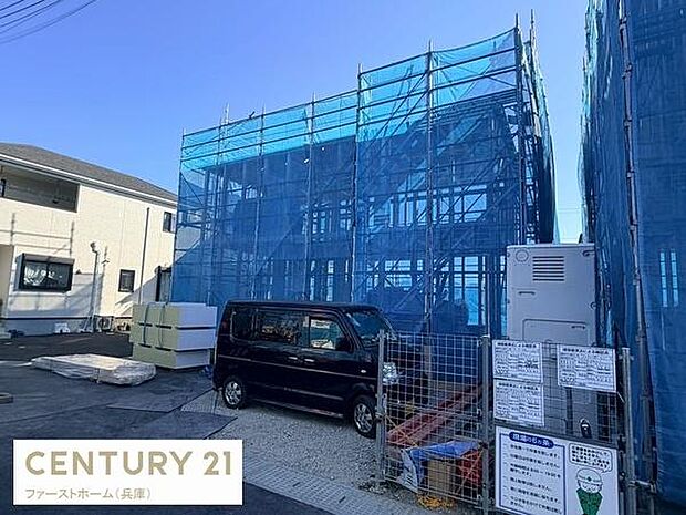 建築中の建物外観が印象的です。青いシートでしっかりと囲われており工事現場の様子がわかります。周辺環境も見通しが良い場所です。敷地内に駐車スペースも確保されています。