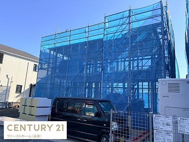 建築中の建物がしっかりとした足場で囲われており整然とした現場の様子がうかがえます。外観の骨組みがしっかりと確認でき進行中の新築工事の雰囲気が伝わってきます。