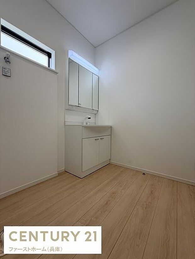 明るい空間が広がる洗面所です。収納スペースが豊富ですっきりとしたデザインが印象的です。清潔感のある白を基調とした洗面台が設置されています。窓から自然光が入り快適に利用できます。