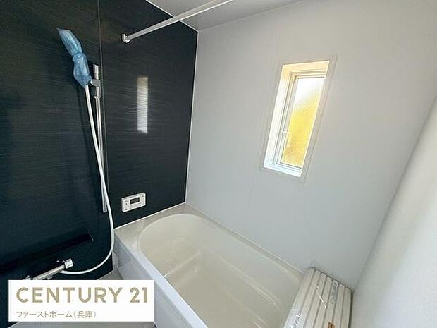 浴室はシンプルかつ清潔感のあるデザインです。浴槽はゆったりとしたサイズ感で窓付きなので換気も便利です。モノトーン調の壁面が空間にメリハリを与えています。シャワーヘッドの位置も調整しやすそうです。