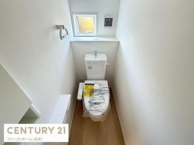 窓付きで自然光が差し込む明るいトイレです。シンプルで使いやすい内装となっています。収納や手洗いスペースも確保され清潔感があります。落ち着いた雰囲気の空間です。