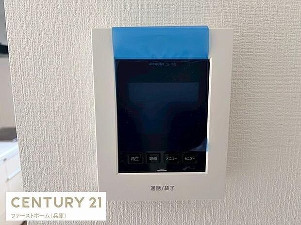 シンプルなデザインのインターホンが設置されています。壁面にしっかり収まっており操作しやすそうです。視認性の高いボタン配置が特徴です。モニター機能が備わっています。新しい設備として安心感があります。