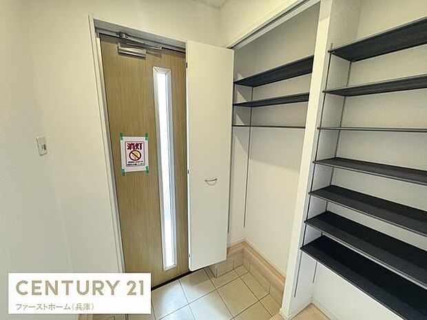 玄関には収納棚が充実しており整理整頓がしやすい空間です。扉の採光窓から明るい光が差し込み開放感があります。タイル部分が広めで靴の出し入れもスムーズに行えます。