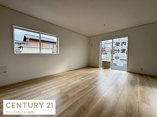 リビングは大きな窓から光が差し込み室内が明るくなっています。シンプルな内装が空間の広がりを感じさせます。床材の木目調が落ち着いた雰囲気を演出しています。