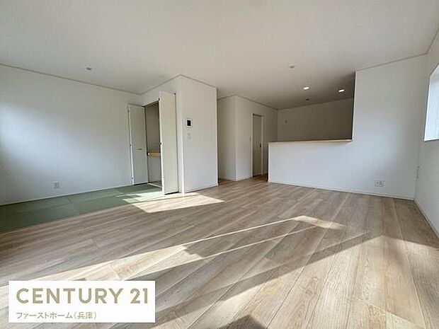 大きな窓から光が差し込むリビングです。木目調の床が空間に温かみを与えています。隣接する和室スペースがアクセントになっています。シンプルな内装で家具の配置がしやすいです。