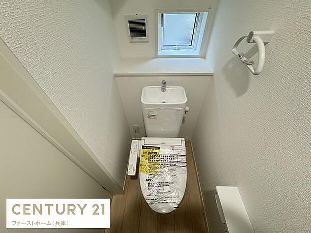 窓があり明るさと換気に配慮されています。温水洗浄機能付き便座を備えています。手洗い器付きでシンプルな内装が印象的です。ペーパーホルダーやタオルリングも設置済みです。