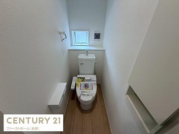 トイレに窓があるため自然光を取り入れることができます。白を基調とした内装で空間が明るく感じられます。床材は木目調でシンプルな雰囲気です。収納スペースも備わっています。