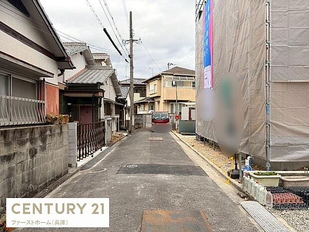 現地の前面道路は舗装されており落ち着いた雰囲気が感じられます。建物の外観や周囲の住宅も確認でき周辺の様子も一目でわかります。