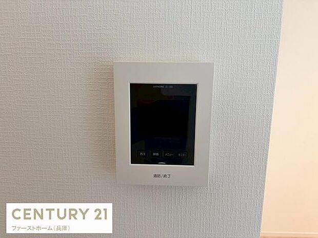 壁に設置されたモニター付きインターホンが特徴です。来訪者を確認できるので安心感があります。シンプルなデザインが壁面に調和しています。操作ボタンも見やすく配置されています。清潔感のある仕上がりです。