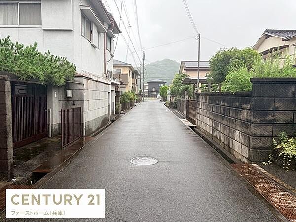 前面道路は舗装されており住宅街の落ち着いた雰囲気が感じられます。周囲には整備された塀や植栽がありきちんとした街並みです。車の通行もスムーズにできる幅が確保されています。
