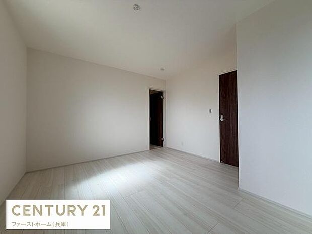 シンプルな内装が特徴の寝室です。明るいフローリングが空間を広く見せています。落ち着いた雰囲気が感じられます。木目調のドアがアクセントとなっています。壁面には余計な装飾がなく自由なレイアウトが可能です。