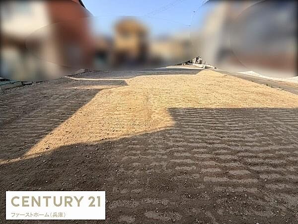 周辺に住宅が立ち並び落ち着いた雰囲気が広がっています。敷地の形状が確認しやすく施工計画も進めやすい現地土地写真です。