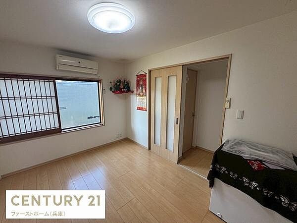 明るい光が差し込む洋室です。スライドドア仕様で空間を有効に活用できます。窓には格子があり安心感もあります。エアコン設置済みで快適な空間が整っています。床は手入れしやすいフローリング仕様です。