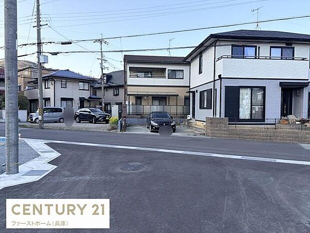 現地の前面道路は舗装されており落ち着いた雰囲気が感じられます。建物の外観や周囲の住宅も確認でき周辺の様子も一目でわかります。