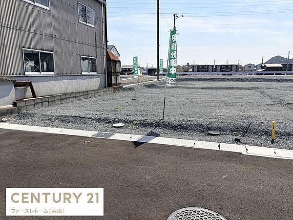 広々とした現地土地写真です。整地されておりお好きなプランで活用いただけます。周辺には建物もあり安心感があります。道路に面しているため出入りもしやすい区画です。旗が目印になっています。