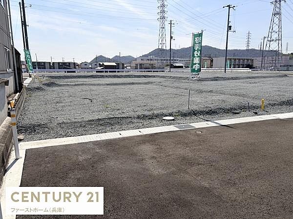 現地土地写真から広々とした敷地の様子が伝わります。周囲に建物が少なく開放感があります。道路へのアクセスも良好です。整然とした整地がされています。
