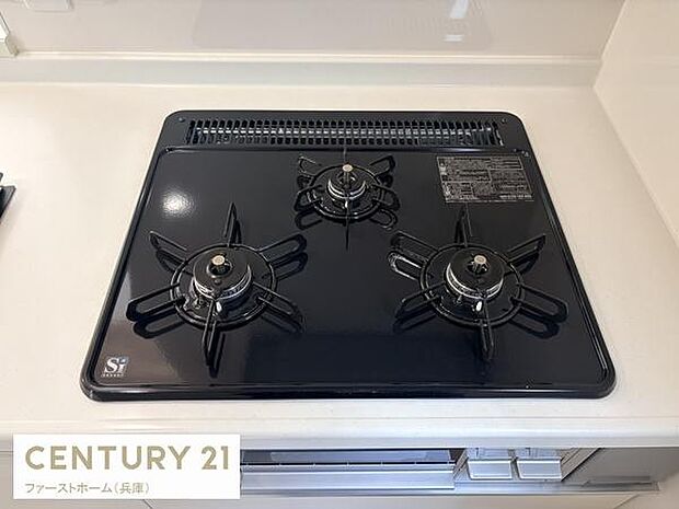 清潔感のあるキッチンに設置された三口コンロです。効率よく調理ができる配置となっています。コンロ周辺もすっきりとした印象です。お手入れもしやすいデザインとなっています。