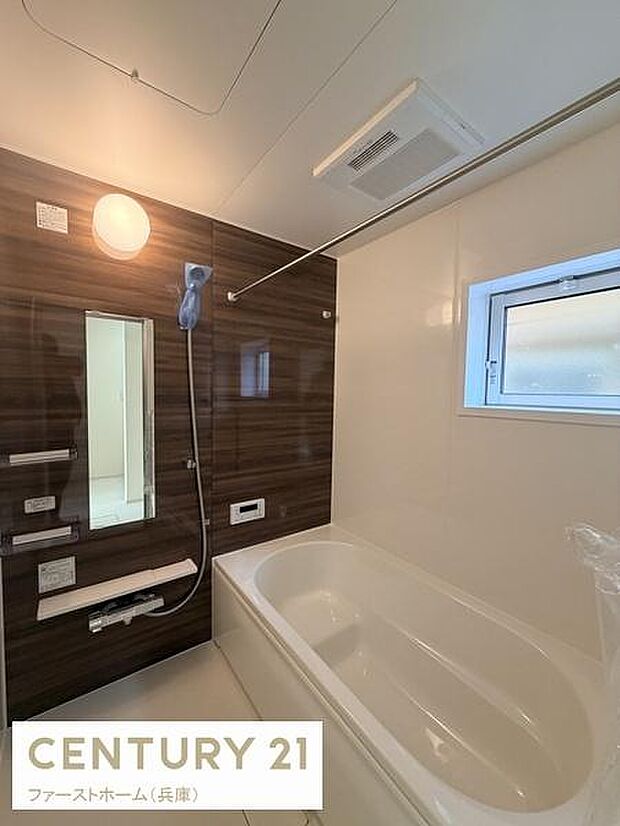 バスルームはシックなダーク調のパネルで落ち着いた印象です。窓付きで換気がしやすく清潔感があります。シンプルなデザインで日々の使い勝手にも配慮されています。