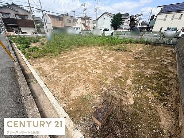 住宅街に位置する現地土地写真です。道路に面しており敷地内は整地されています。周囲には住宅が立ち並び静かな環境が広がっています。駐車スペースや庭など多様な活用が考えられる土地です。