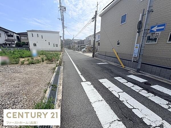 前面道路は見通しが良く周辺には住宅が立ち並んでいます。電柱や標識も整備されており安心感があります。敷地の様子も写真から確認できます。周囲は落ち着いた雰囲気です。
